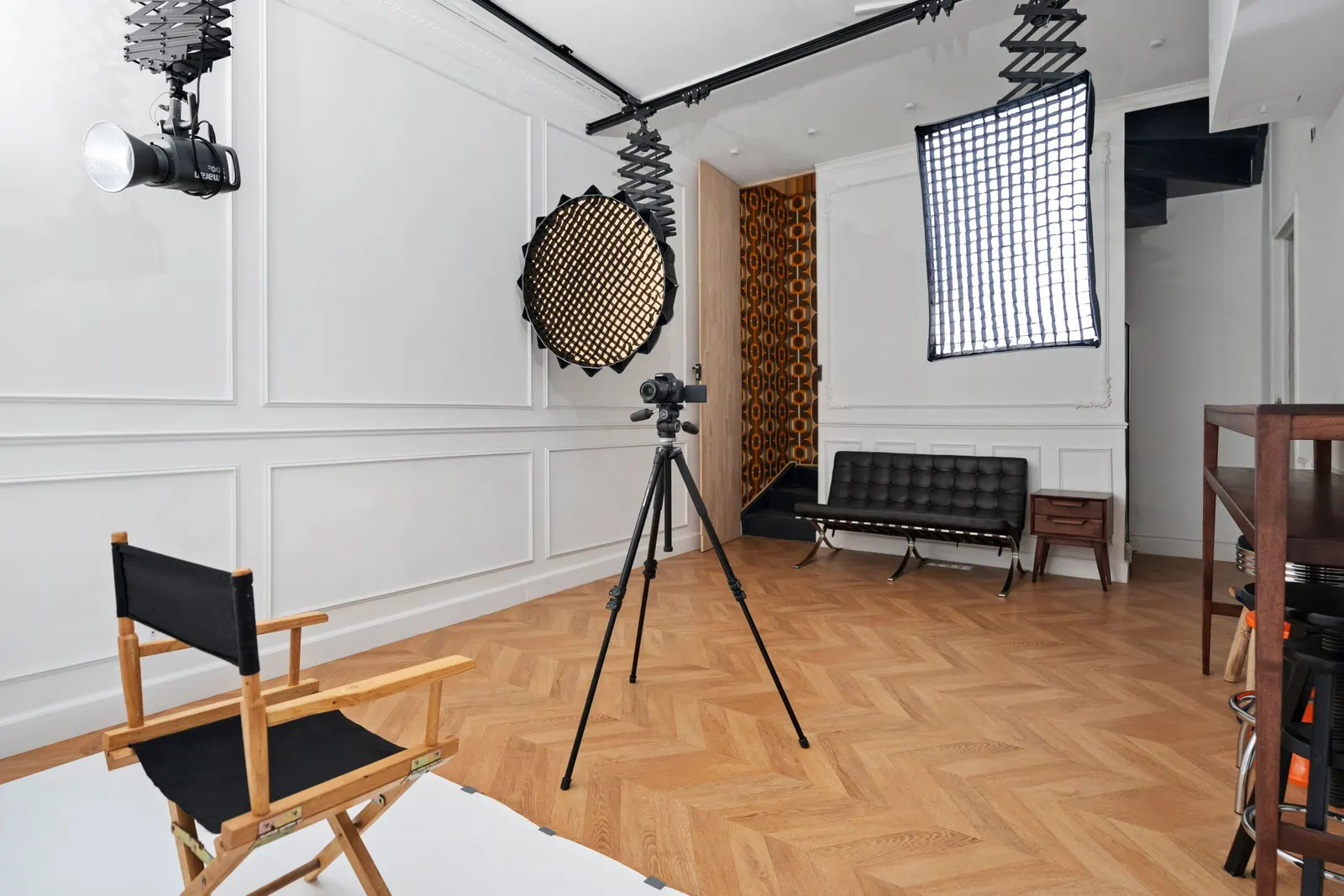 Plateau photo équipé avec trépied, éclairages suspendus et parquet en chevrons